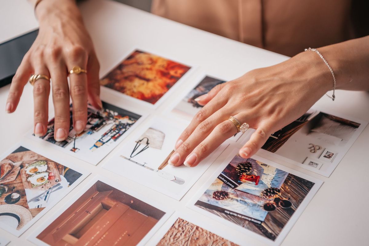 Photographe organisant ses tirages photo sur un plan de travail
