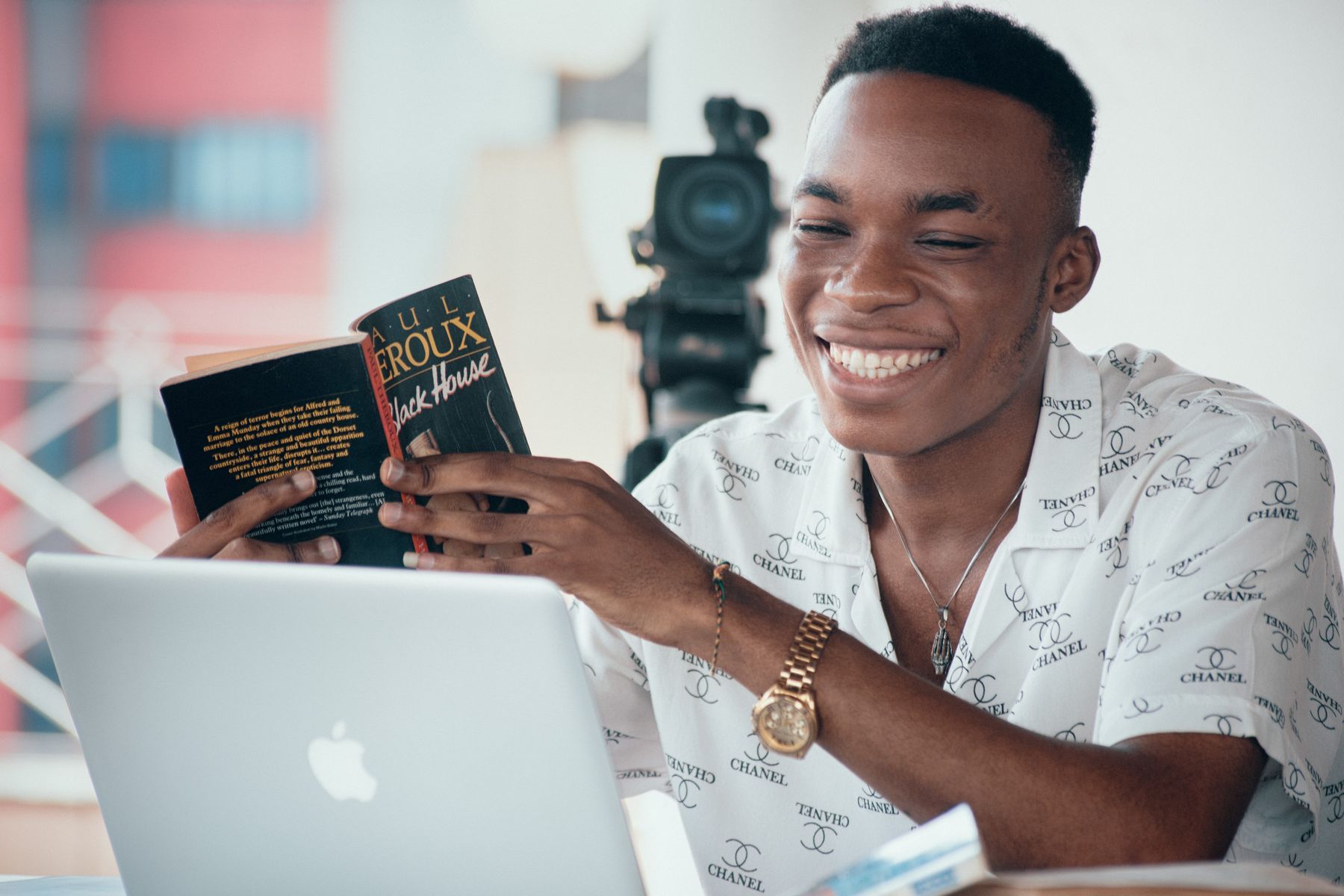 Jeune entrepreneur souriant travaillant sur son ordinateur portable avec des documents de lecture