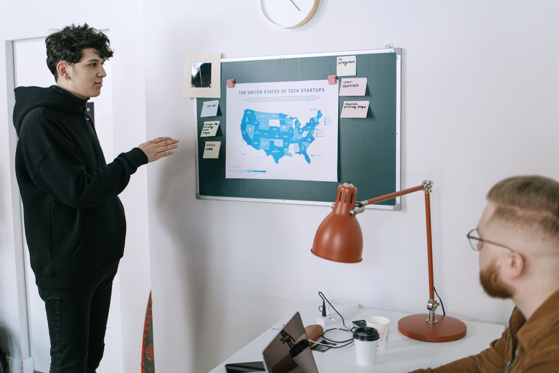 Équipe réunie autour d'une table de conférence devant une carte murale des États-Unis
