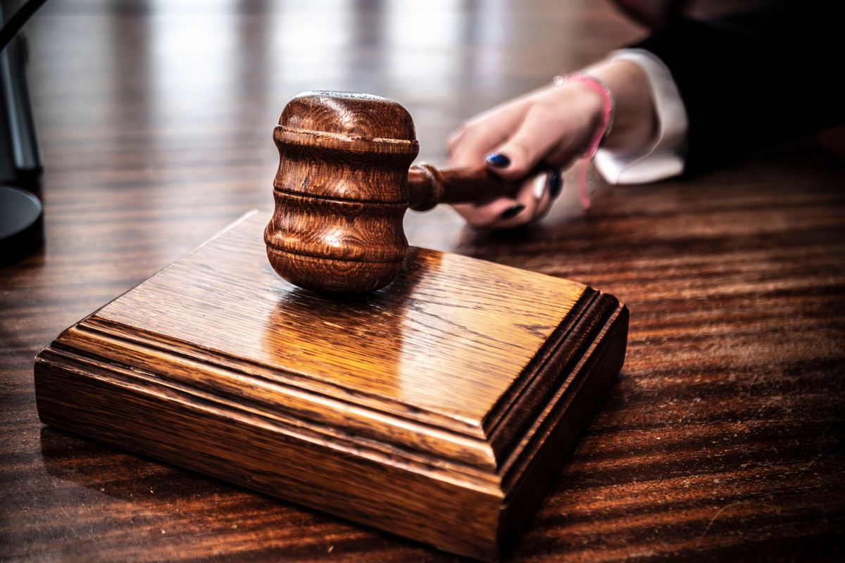 Maillet en bois sur le bureau d'un mandataire judiciaire symbolisant l'autorité et la justice