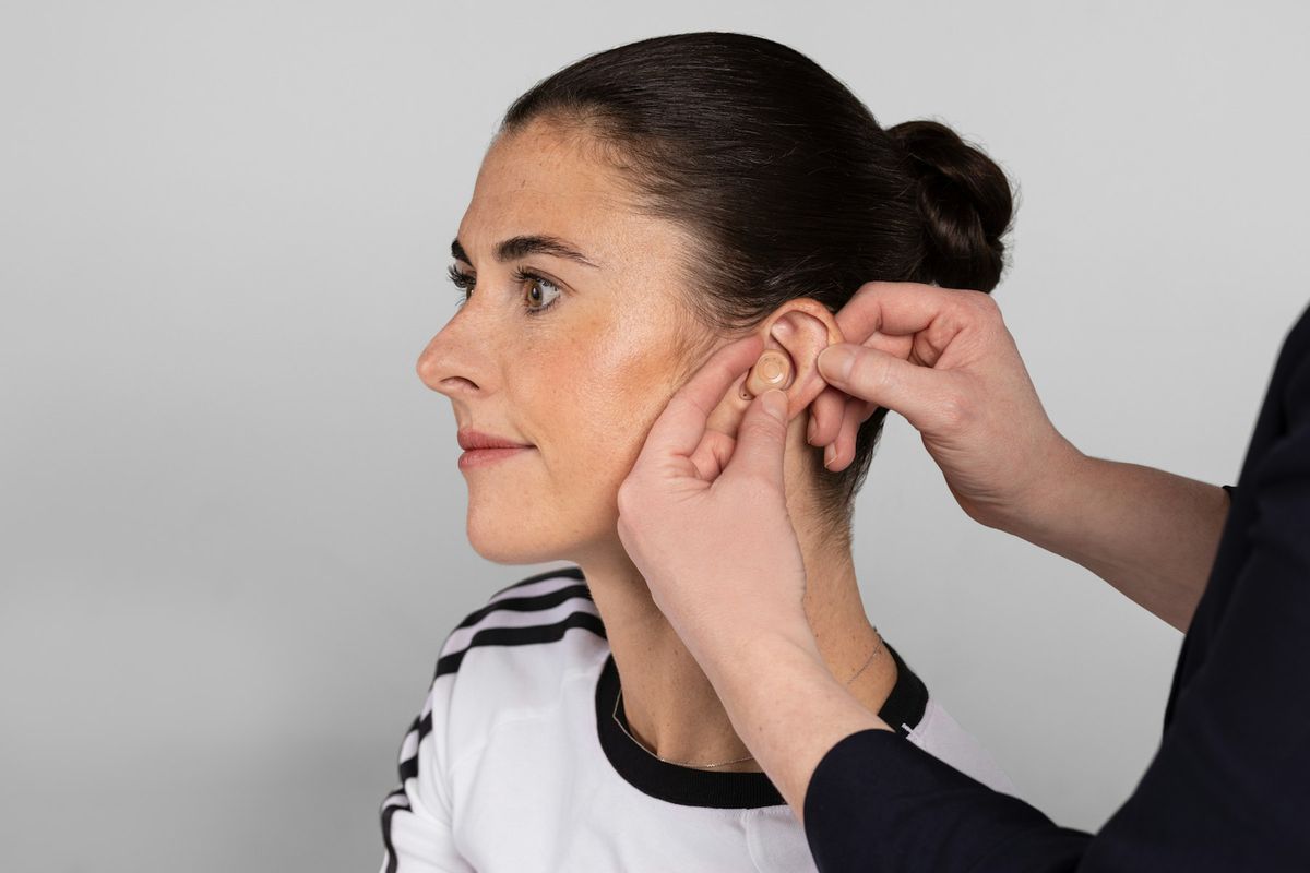 Une femme insère des bouchons auriculaires dans son oreille