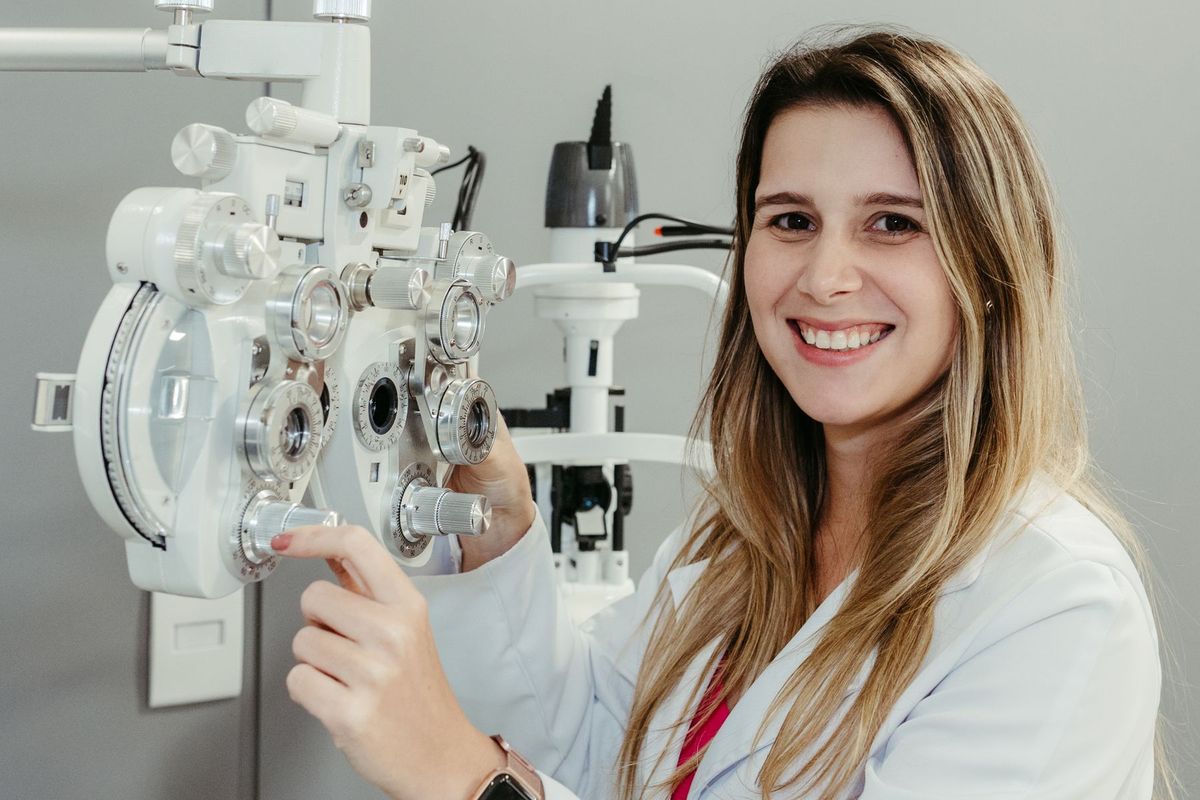 Opticienne souriante examinant la vision d'un patient avec un phoroptère