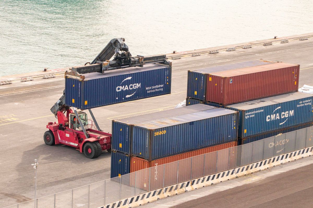 Chariot élévateur manipulant des conteneurs colorés sur un quai portuaire