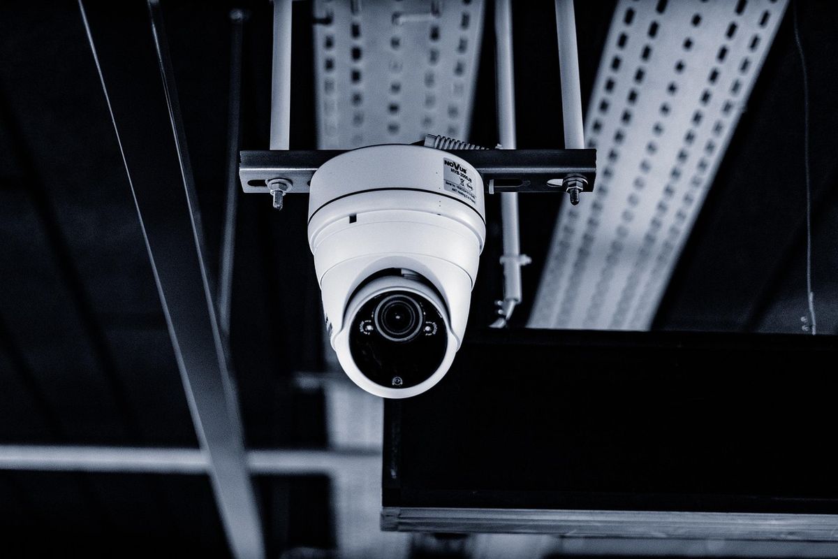 Caméra de surveillance montée au plafond, pointée vers le bas pour couvrir une zone de sécurité