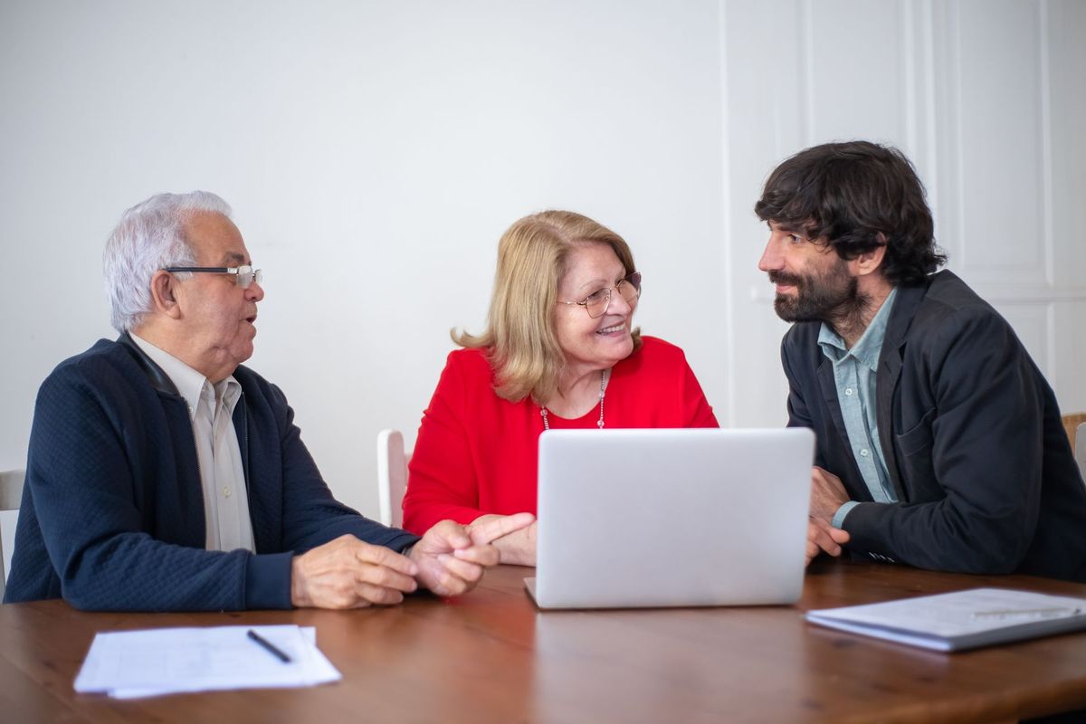 Couple en consultation avec un conseiller autour d'un bureau dans un bureau lumineux
