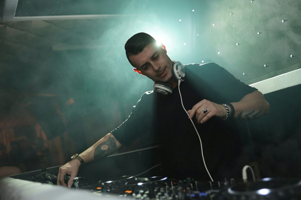Un DJ manipule les platines et le mixeur lors d'une performance musicale