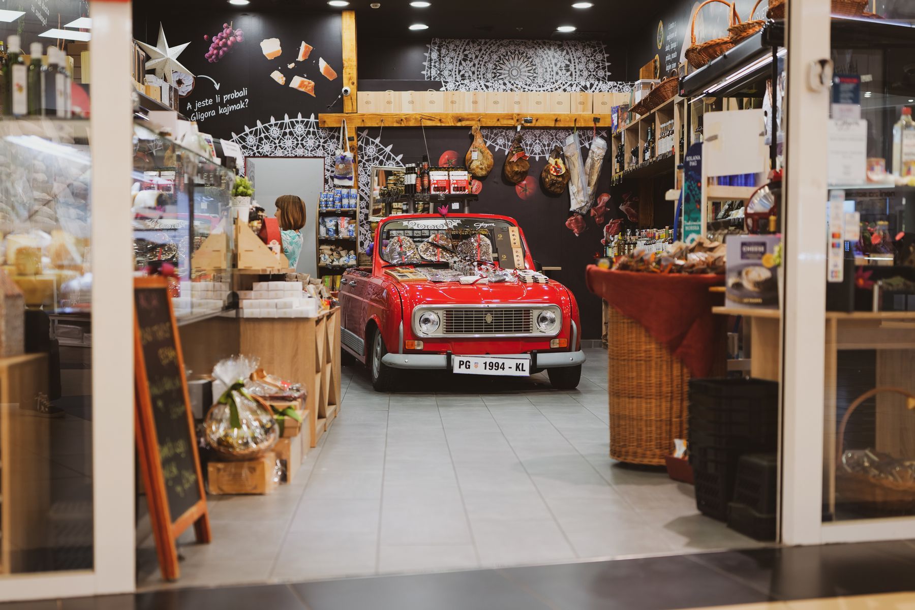 Voiture rouge vintage stationnée à l'intérieur d'un supermarché moderne