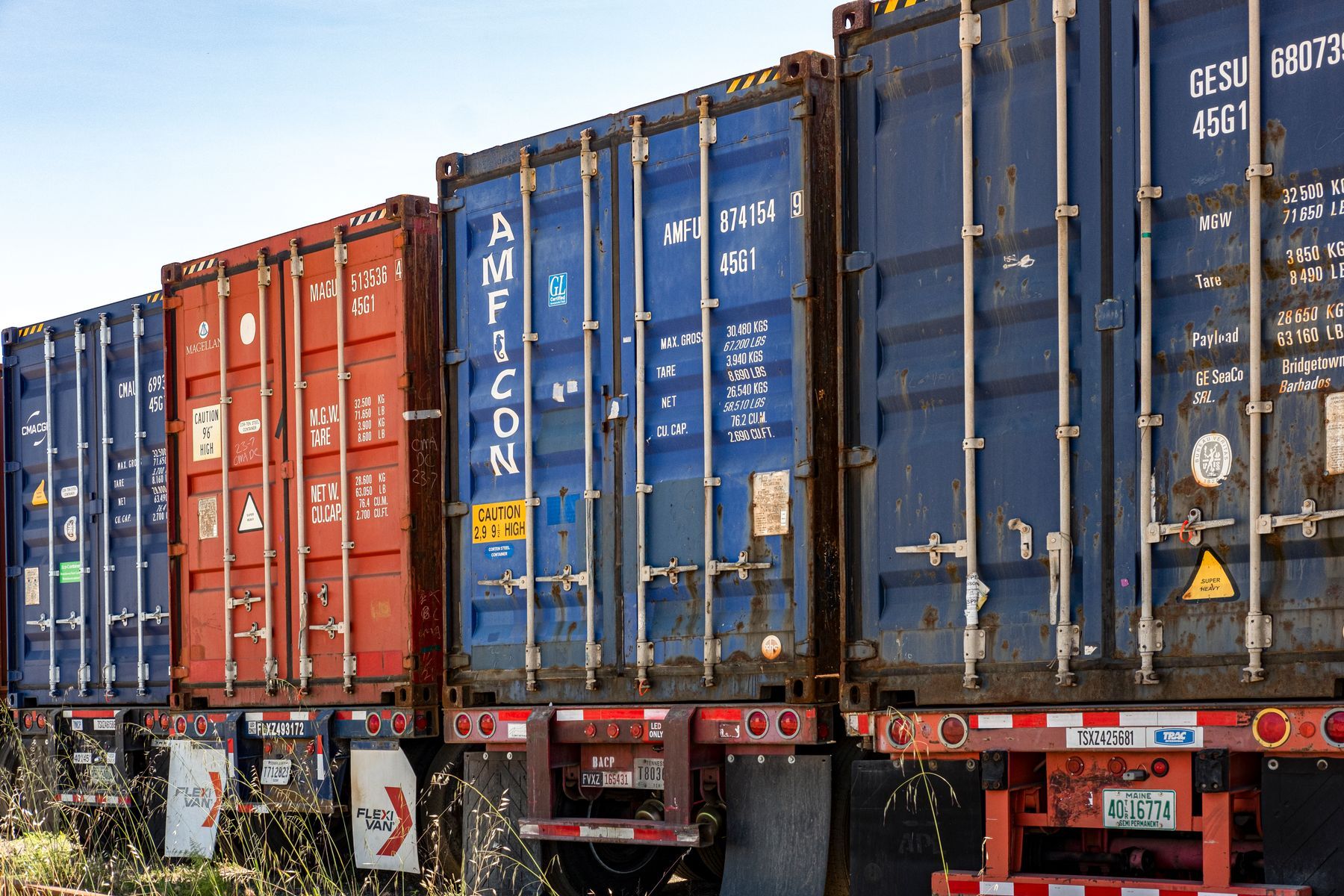 Containers de fret colorés alignés dans une cour d'expédition industrielle
