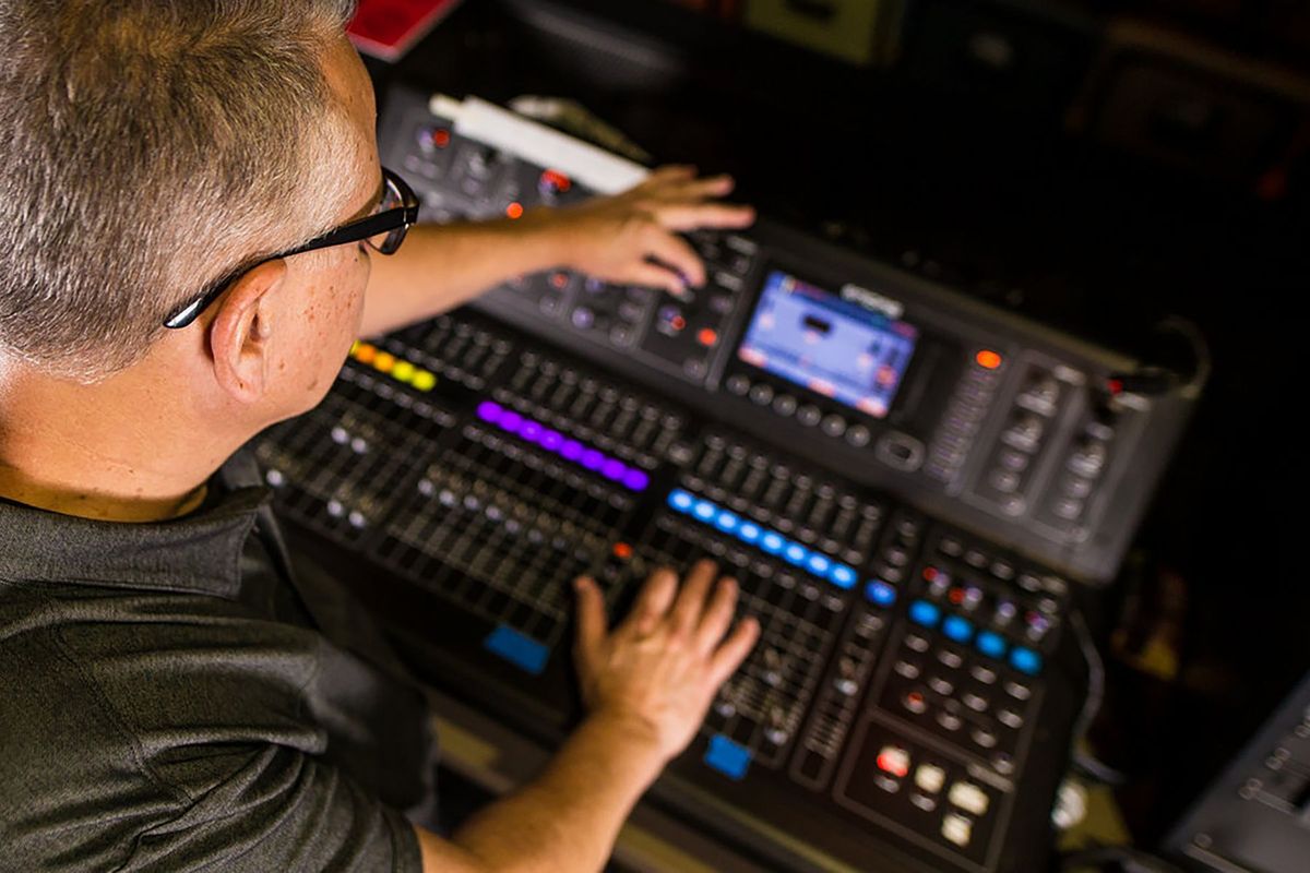Technicien son ajustant les curseurs d'une console de mixage dans un studio professionnel