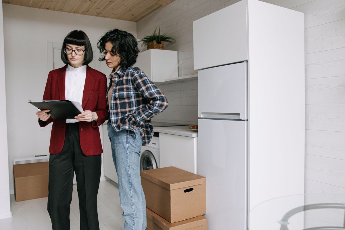 Deux femmes consultent des documents administratifs entourées de cartons de déménagement
