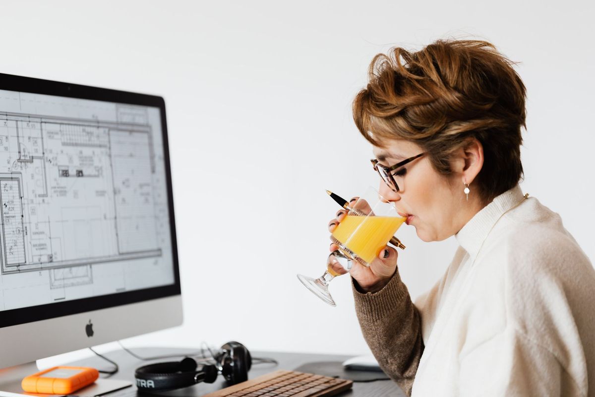 Femme concentrée devant son écran, travaillant sur du code informatique à son bureau