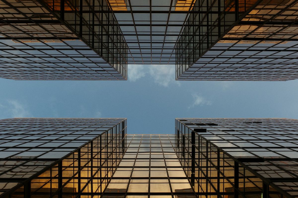 Immeubles modernes photographiés en contre-plongée sous un ciel nuageux