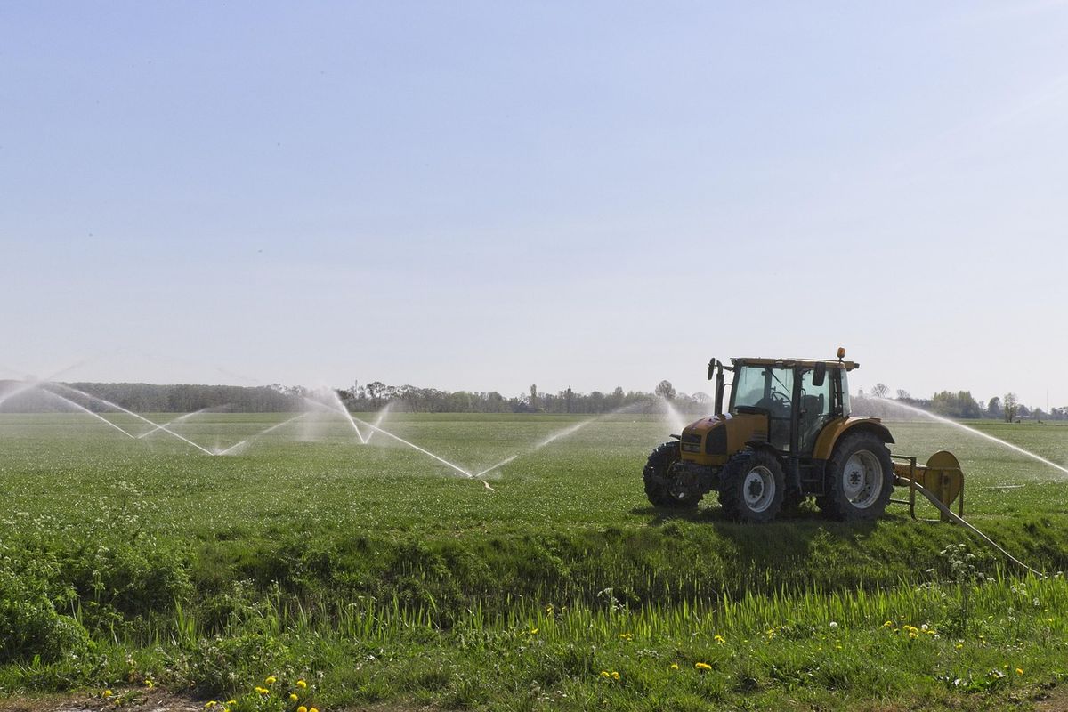 Tracteur équipé d'un système d'irrigation pulvérisant l'eau sur les cultures