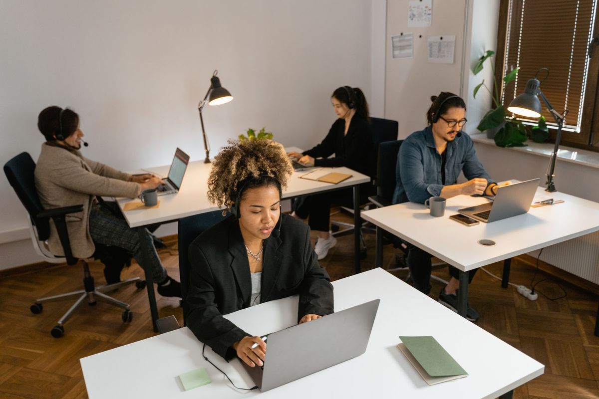 Agents de centre d'appels concentrés à leurs postes de travail dans un bureau moderne