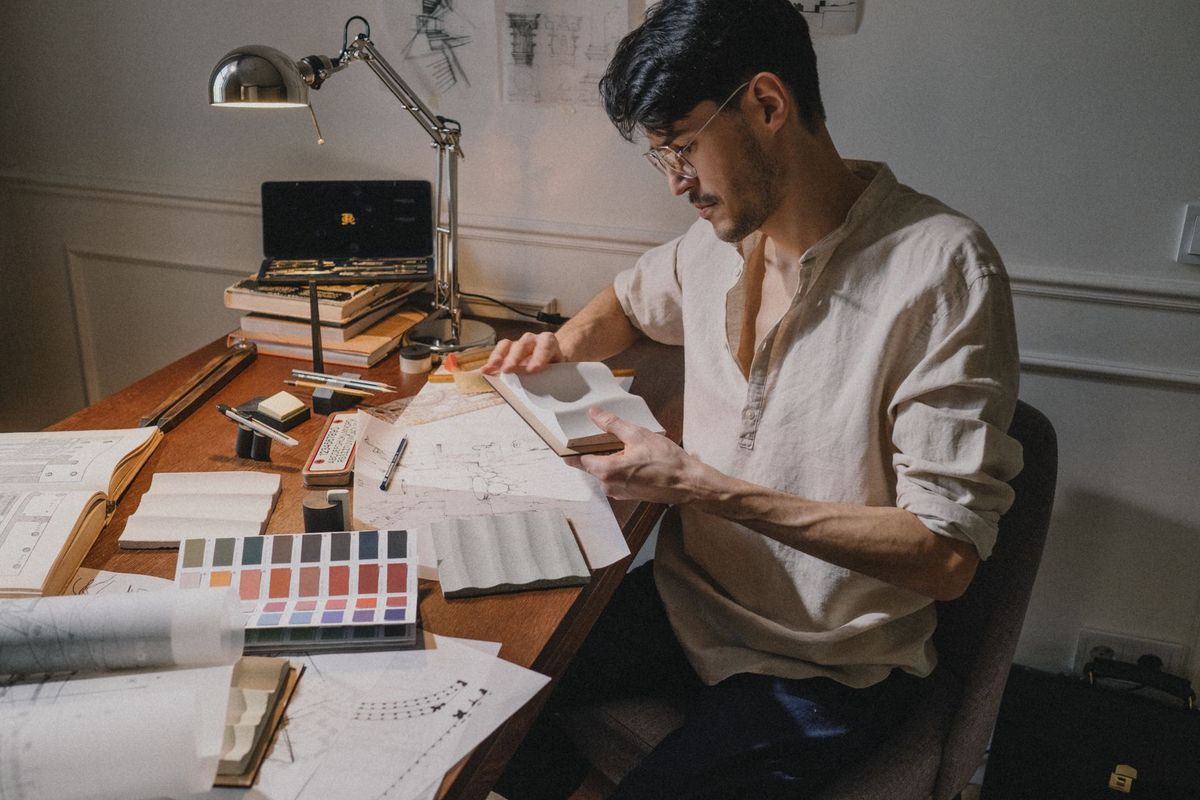 Architecte d'intérieur consultant des plans et des échantillons de matériaux sur son bureau