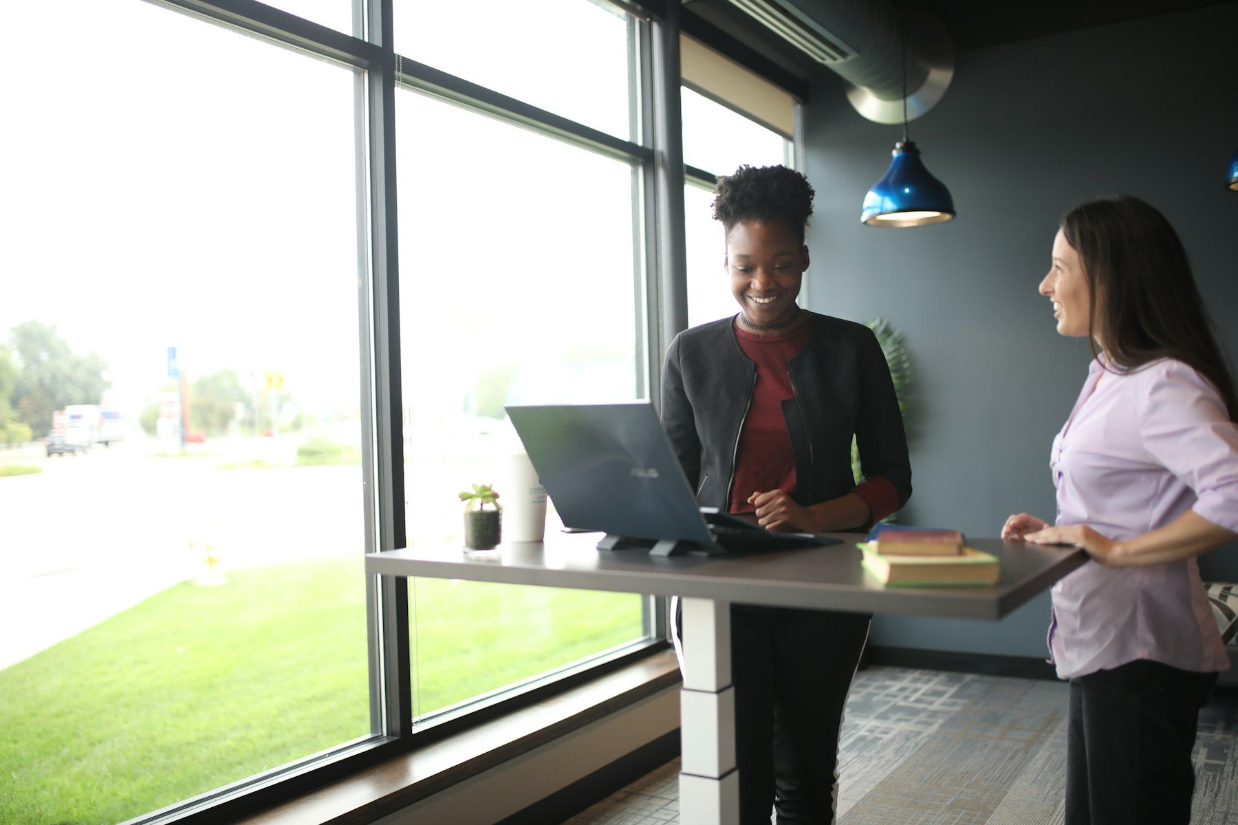 Femme assise à son bureau face à son ordinateur portable en train de travailler