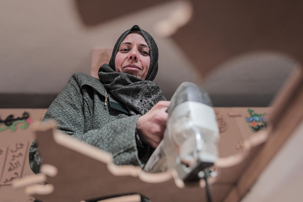 Menuisière en hijab utilisant une perceuse dans son atelier de travail du bois