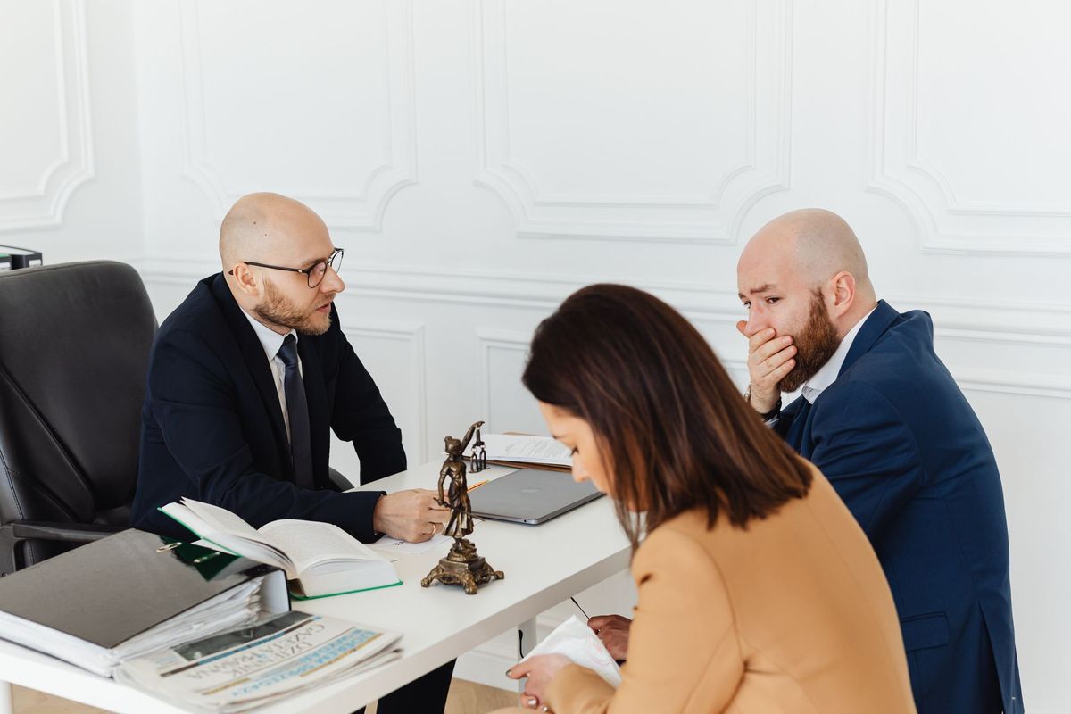Trois professionnels en discussion autour d'un dossier dans un bureau moderne