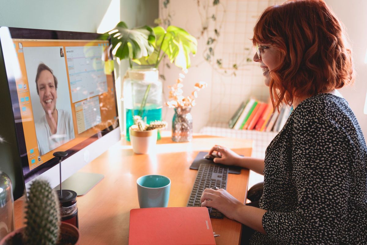 Femme en visioconférence depuis son bureau à domicile lumineux