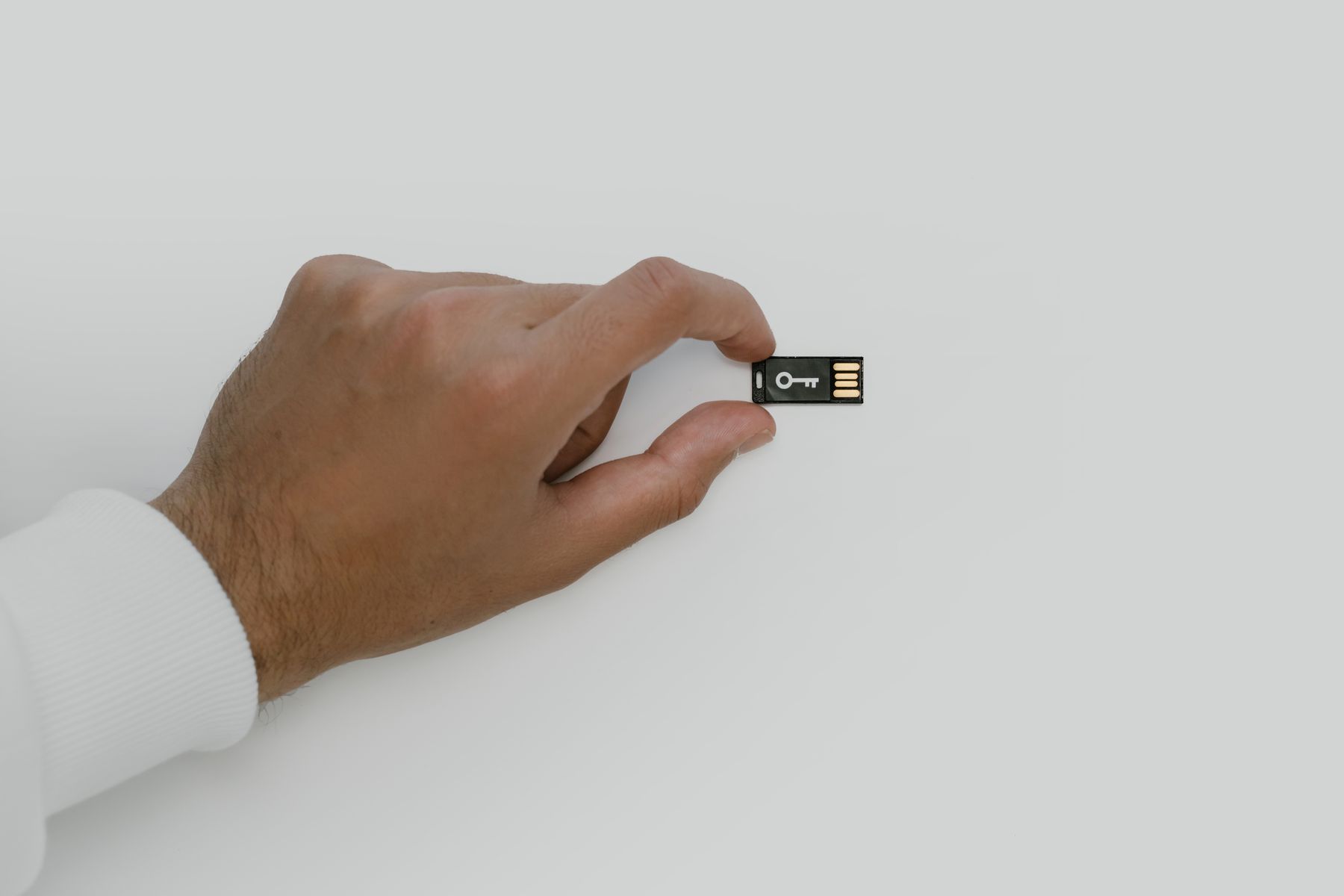 Main tenant une clé USB symbolisant la sécurité et la protection des données numériques