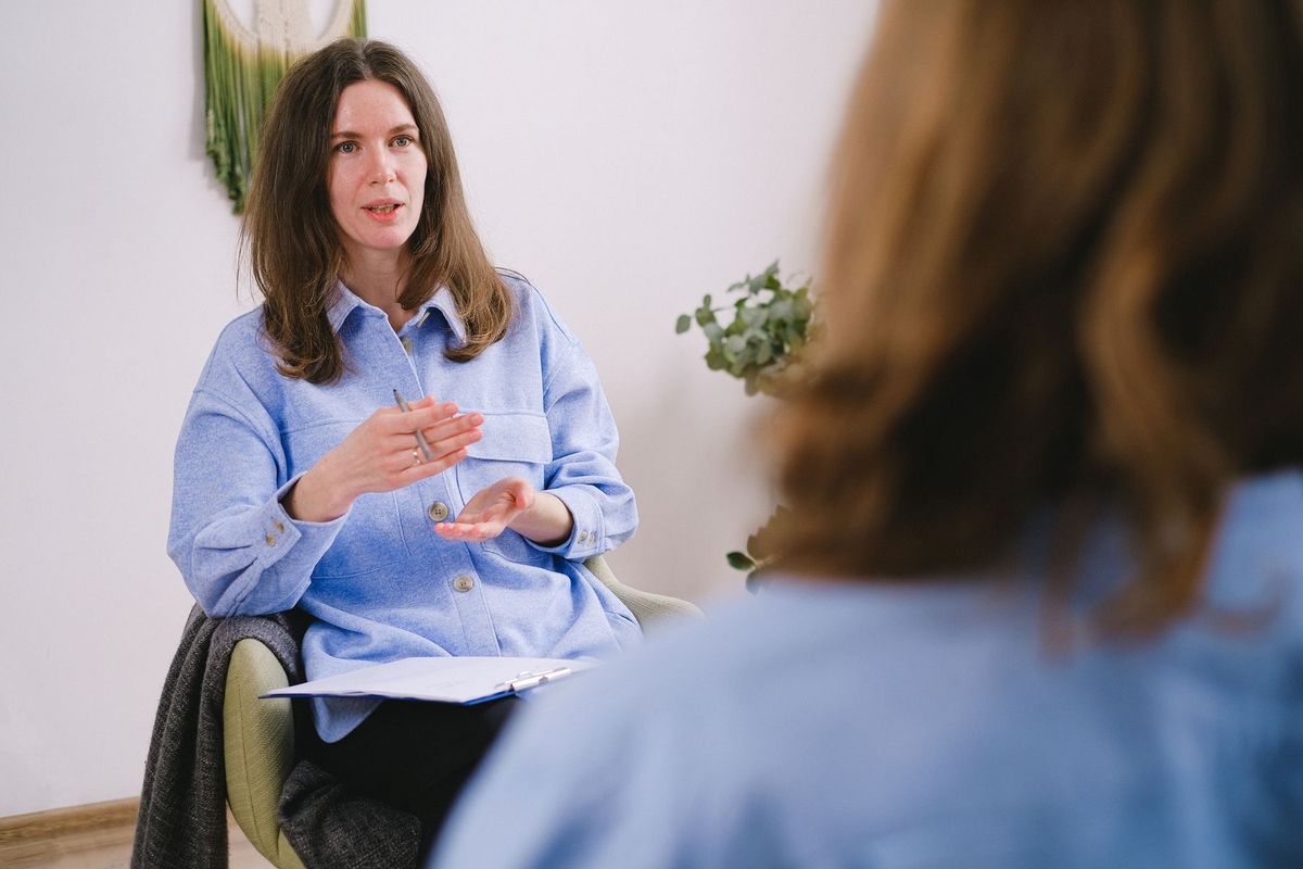 Une sophrologue écoute attentivement son patient lors d'une séance de relaxation et de bien-être