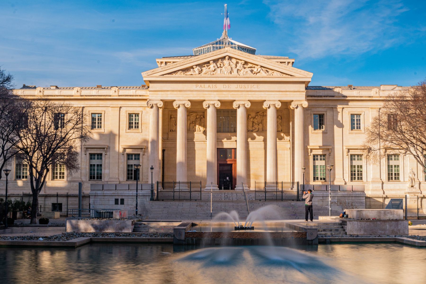 Façade imposante du Palais de Justice avec sa fontaine, symbole de justice et d'autorité judiciaire
