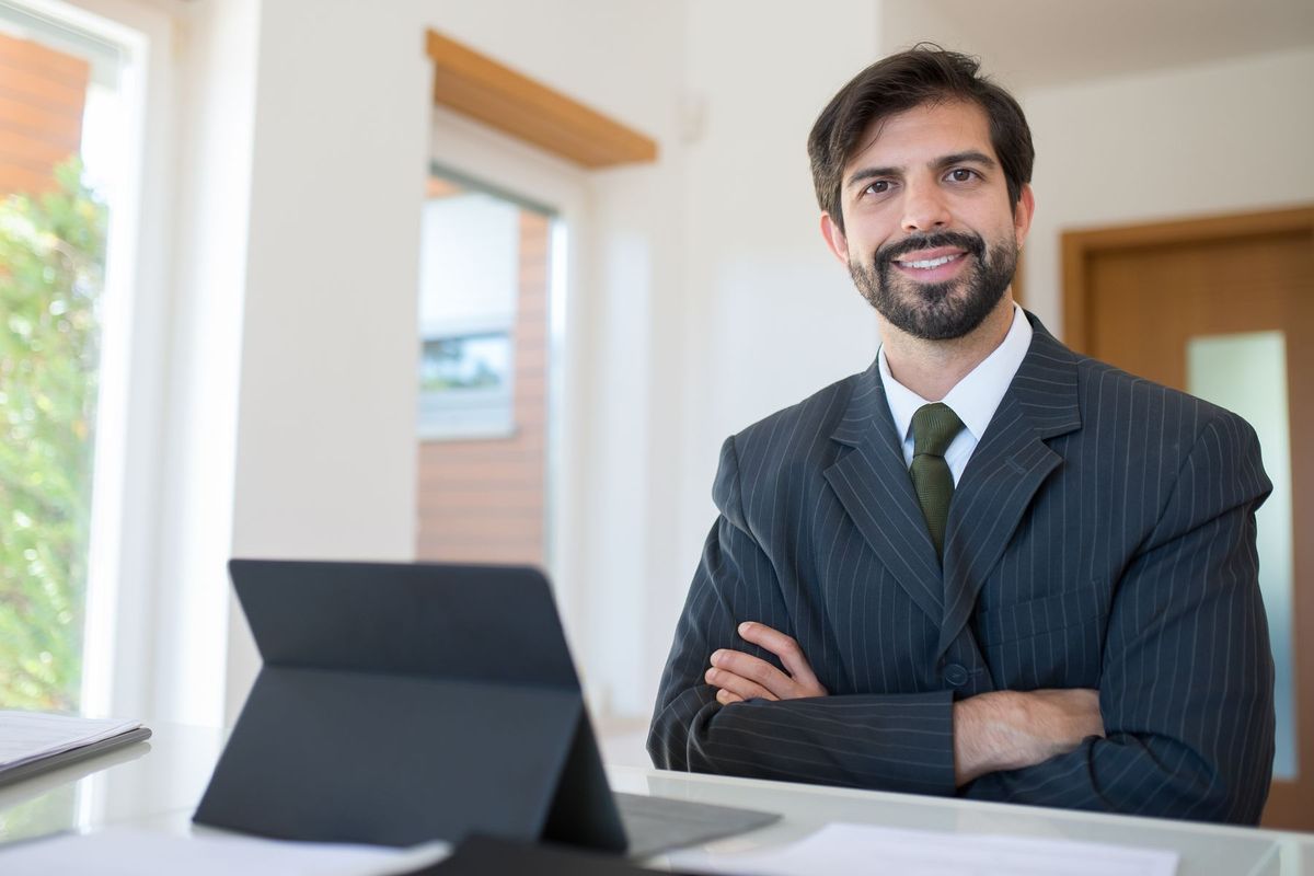 Consultant en costume consulte des données sensibles sur sa tablette dans son bureau
