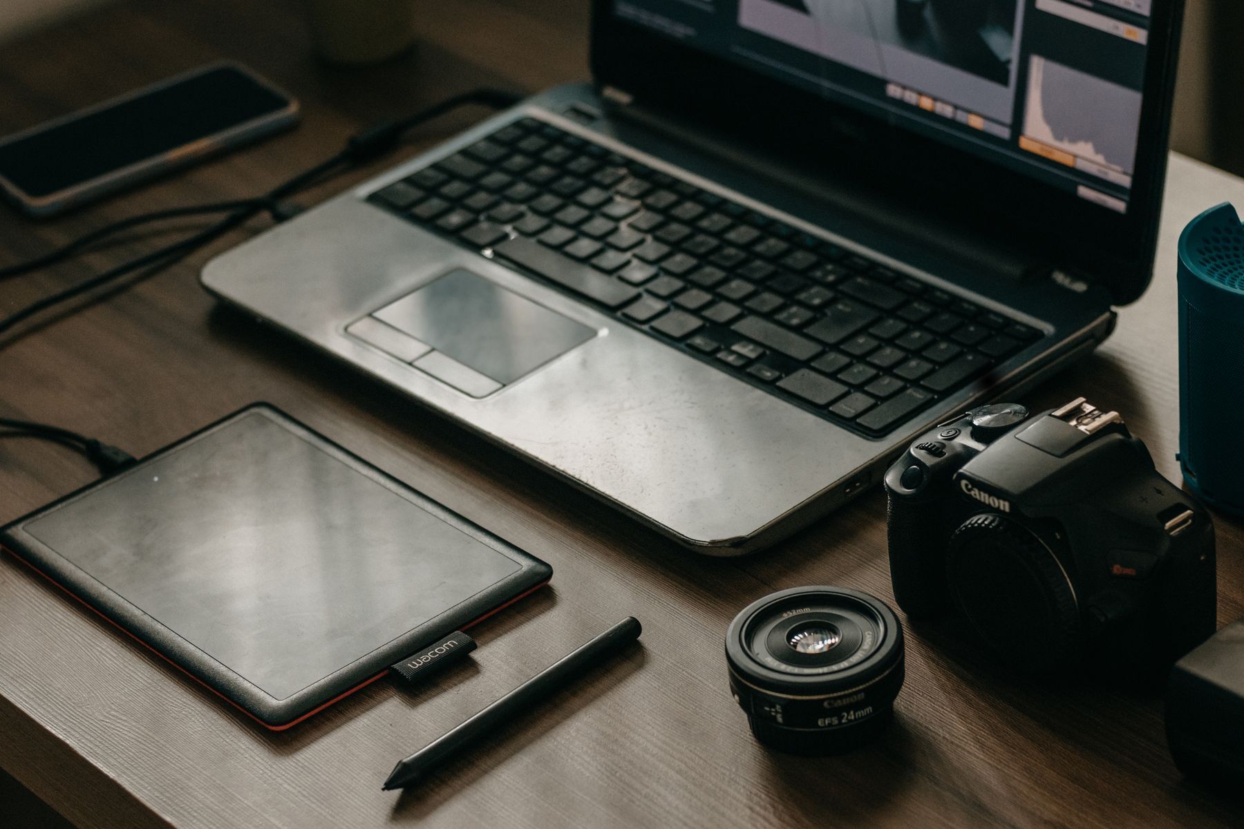 Outils de travail d'un créatif numérique : ordinateur portable, appareil photo, objectif et tablette graphique