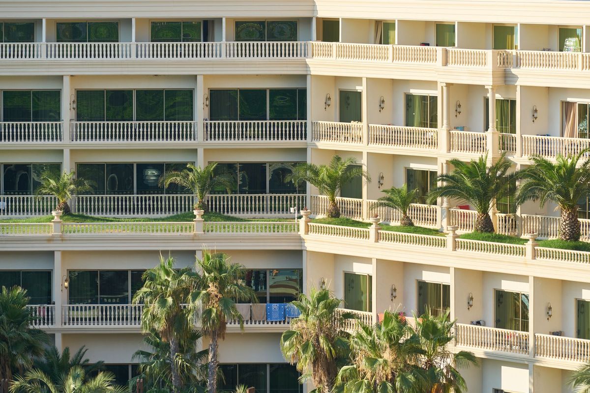 Immeuble résidentiel avec balcons et palmiers en zone touristique