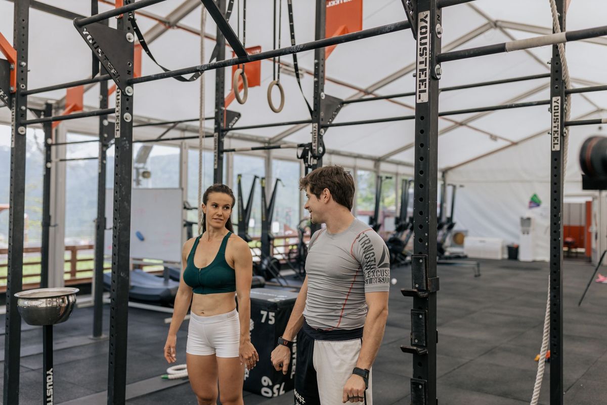 Deux athlètes s'entraînent intensément aux barres de traction dans une salle de crossfit