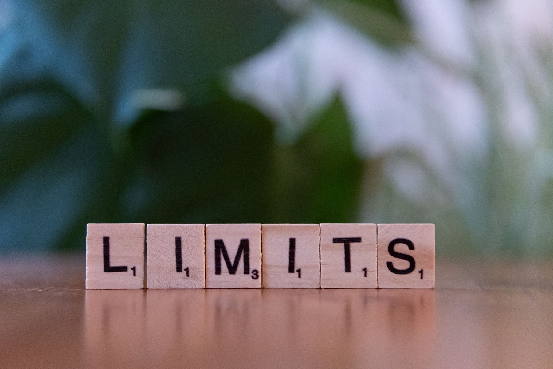 Tuiles de lettres en bois épelant le mot LIMITS sur une surface en bois