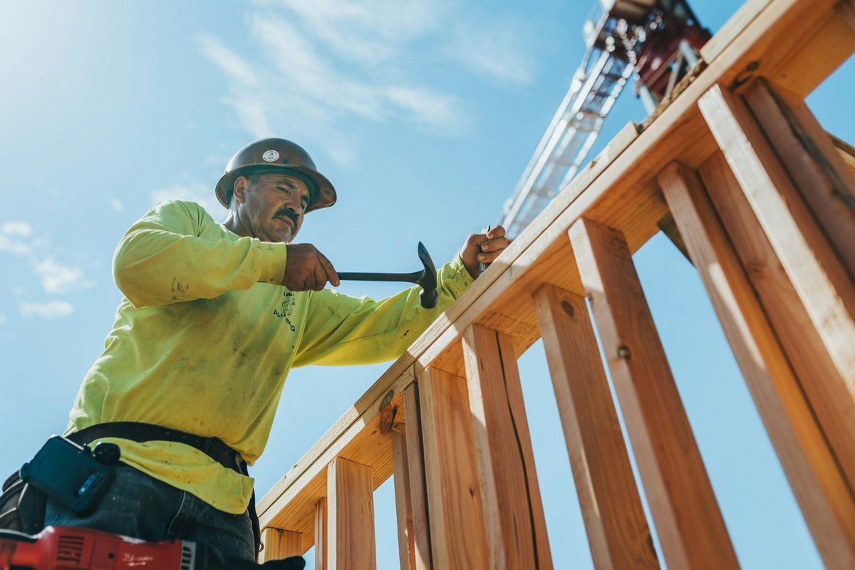 Ouvrier en casque et équipement de sécurité construisant une structure en bois