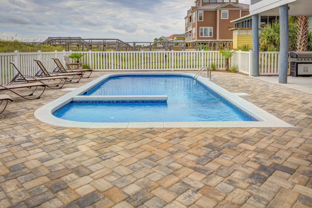 Piscine avec chaises longues et terrasse aménagée pour la détente et les loisirs aquatiques