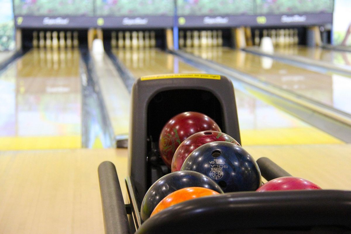 Boules colorées alignées sur une allée de bowling avant le lancer