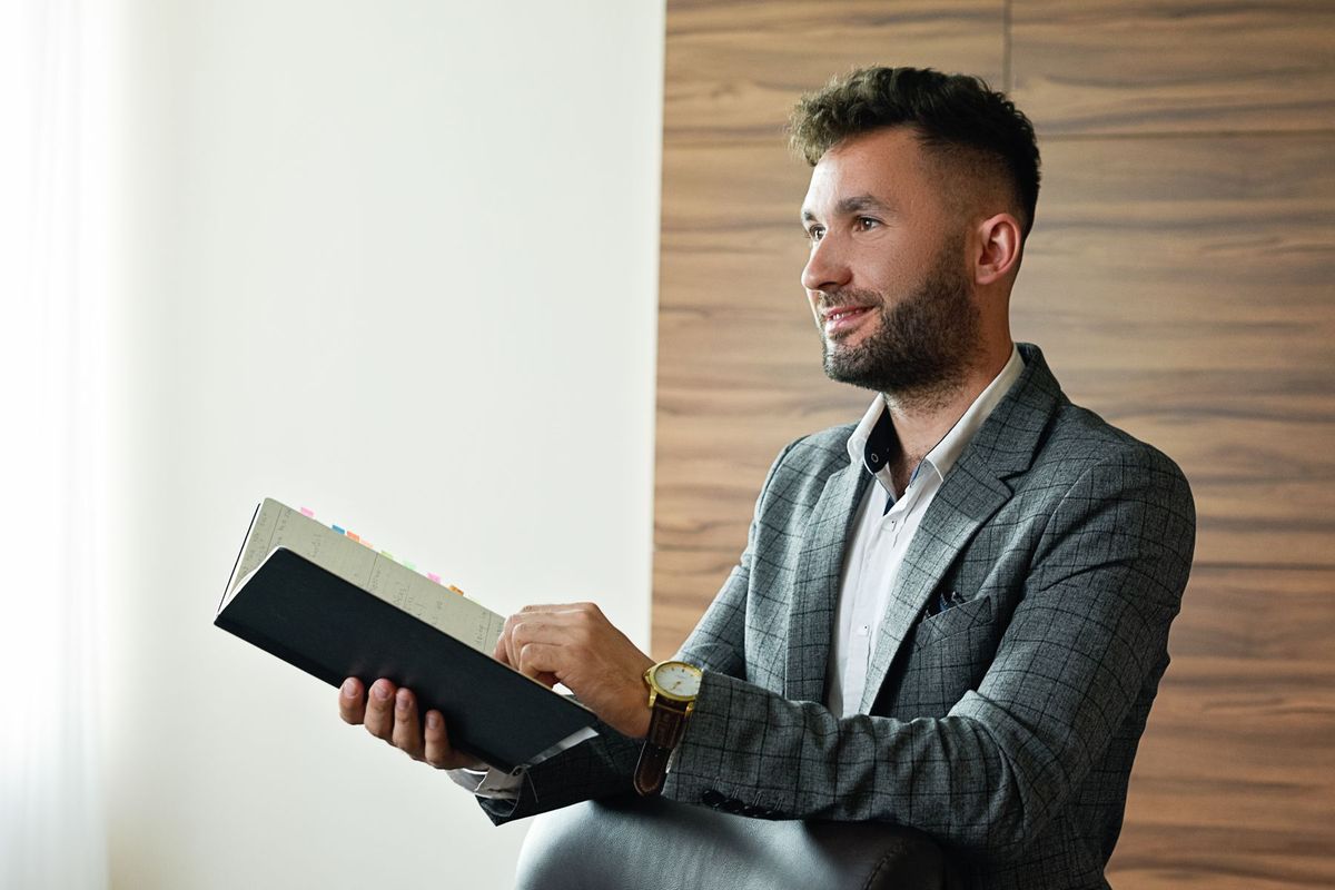 Consultant en costume prenant des notes sur son carnet dans un bureau moderne