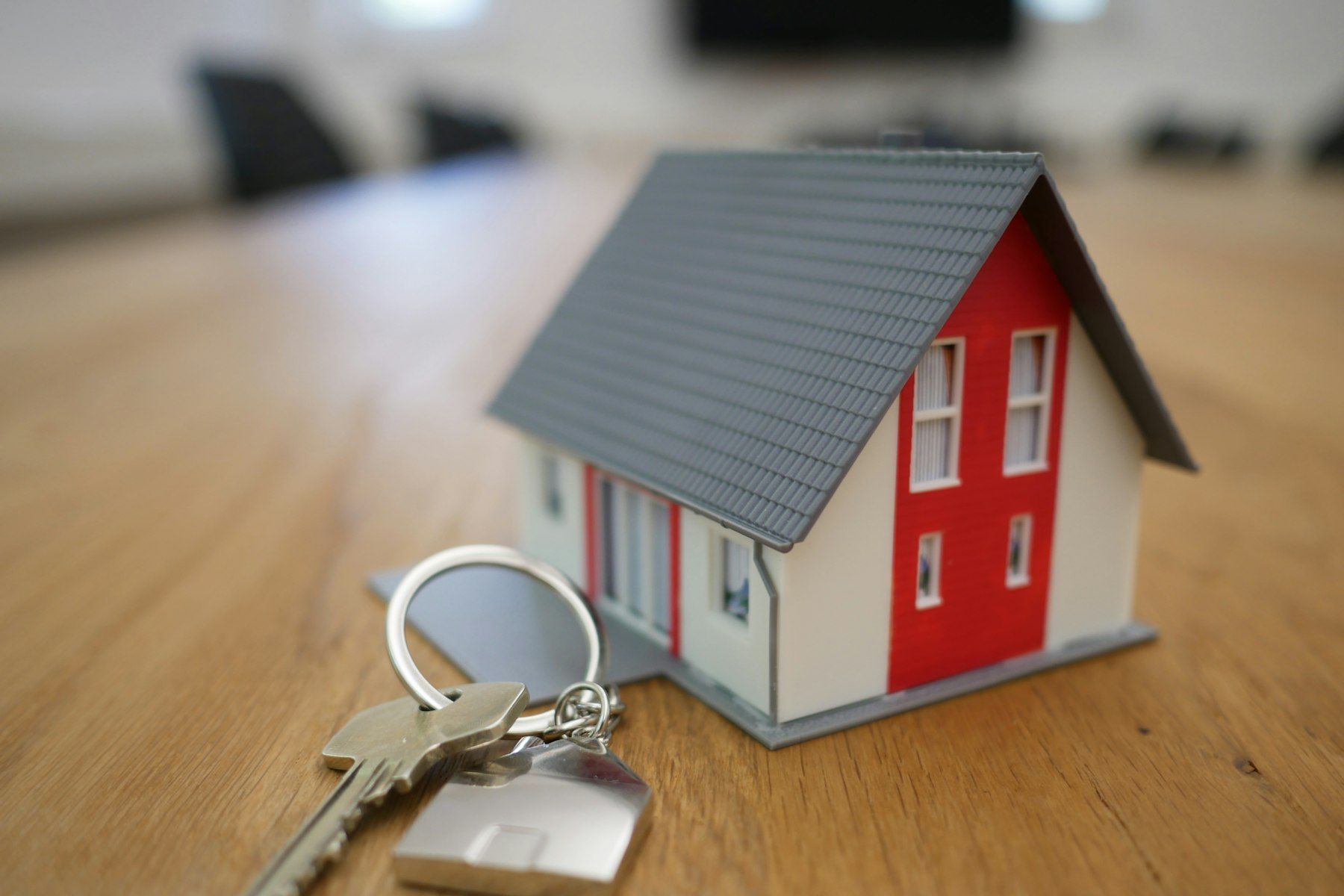 Miniature de maison blanche et rouge en bois posée sur une table marron