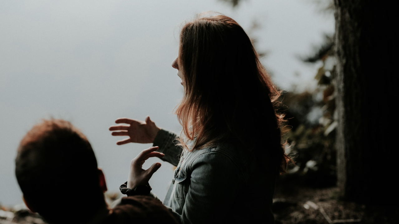 Two people talking side-by-side. 