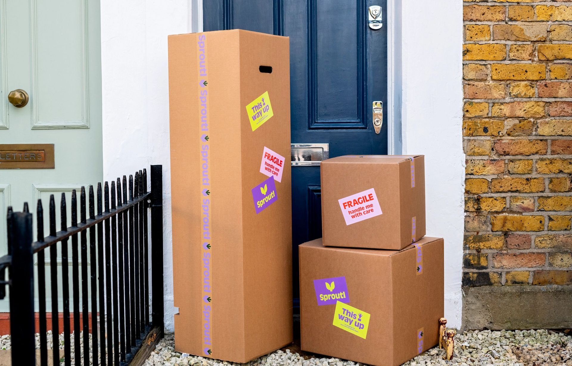 Pile of cardboard boxes outside a blue front door