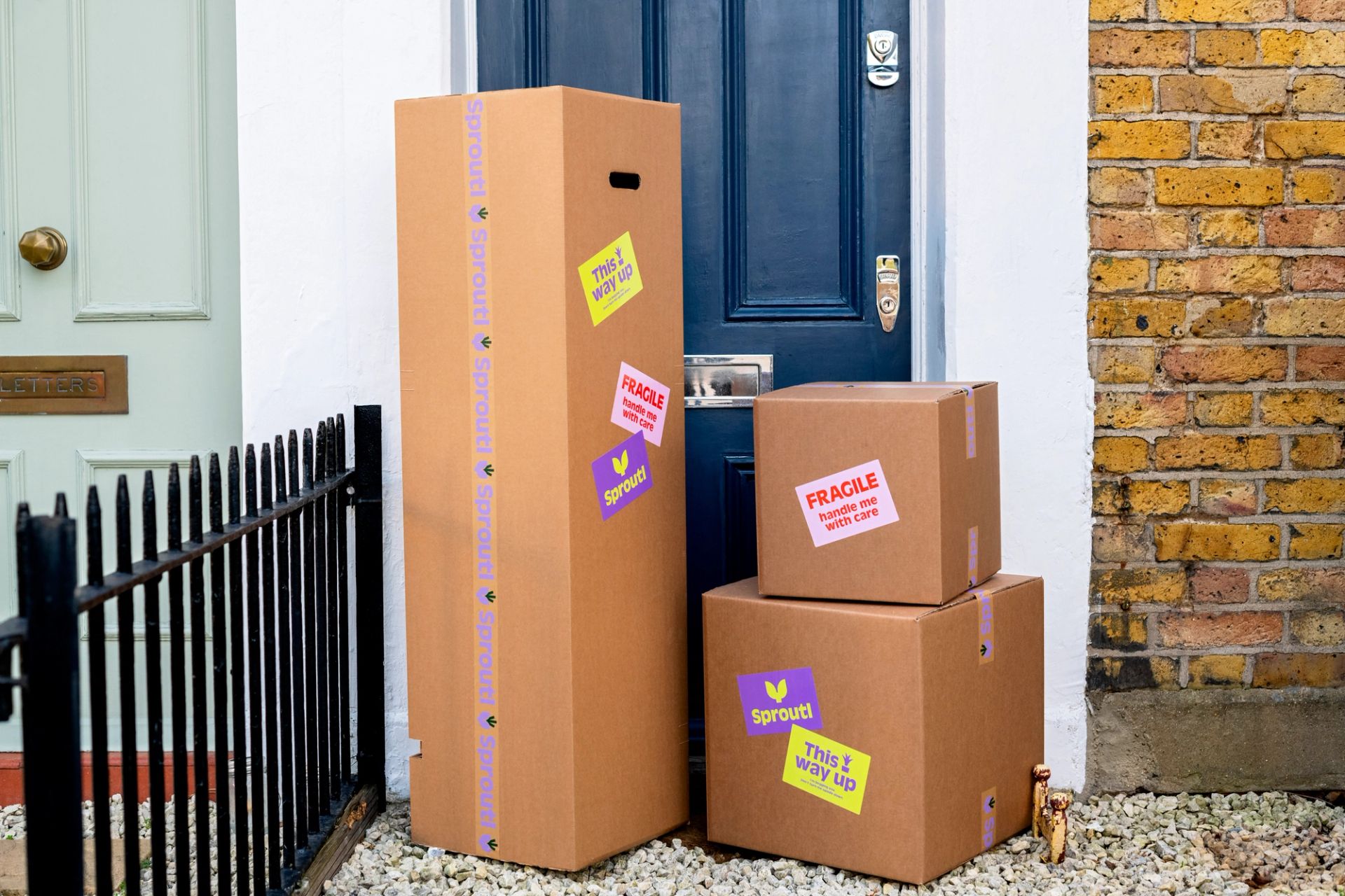 Pile of cardboard boxes outside a blue front door