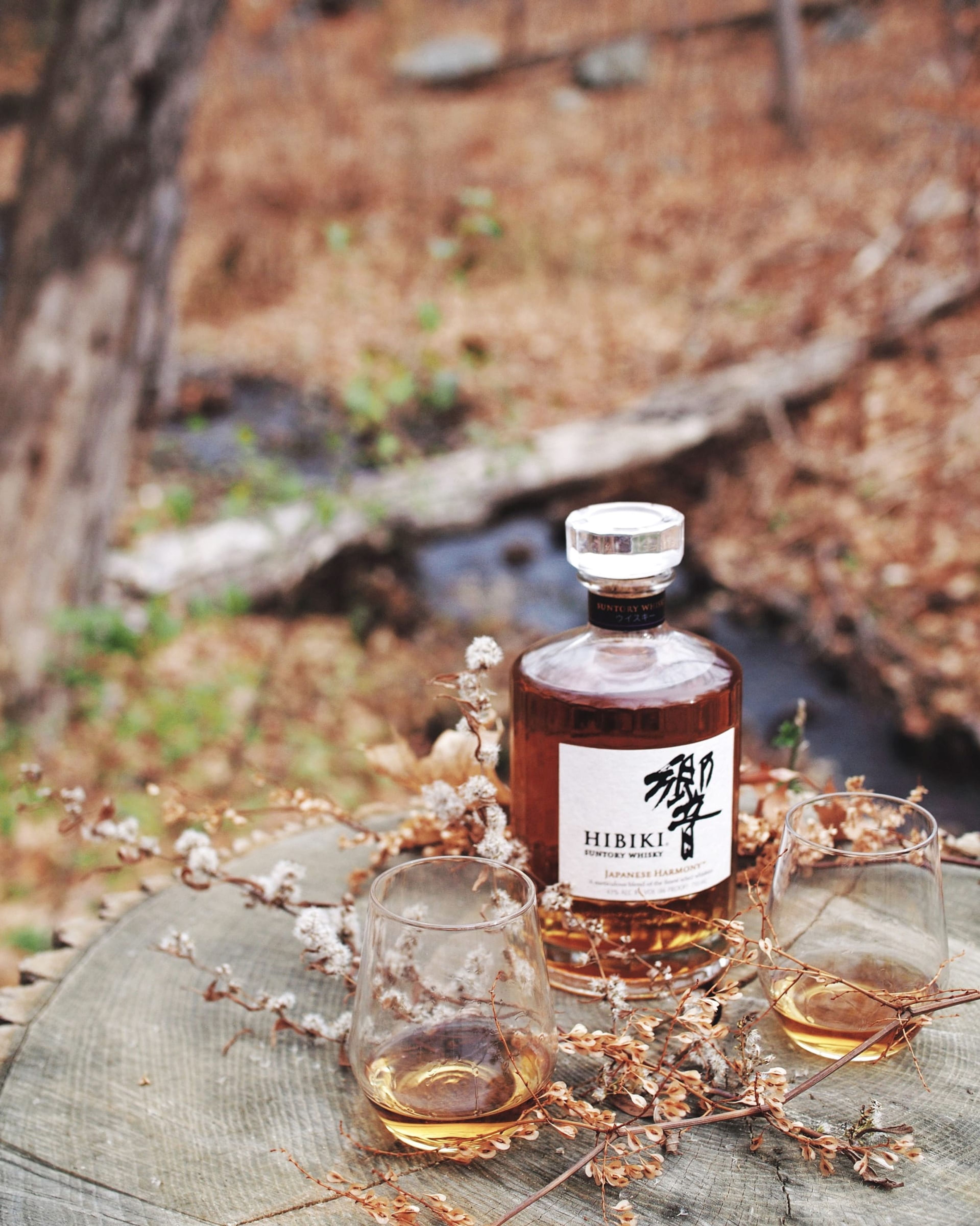 Suntory Hibiki whisky bottle and glasses outdoors