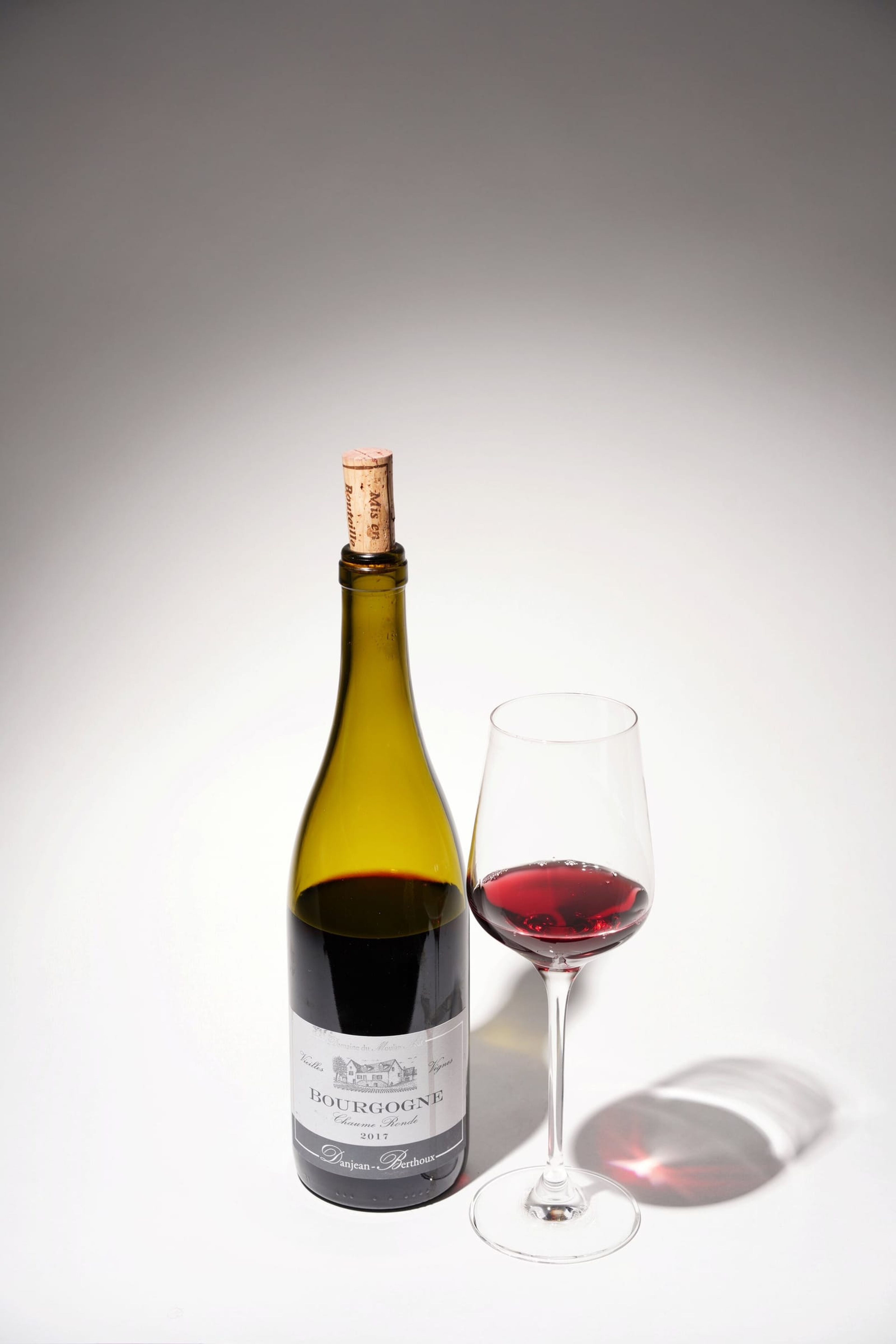 Bottle of red wine beside a poured glass