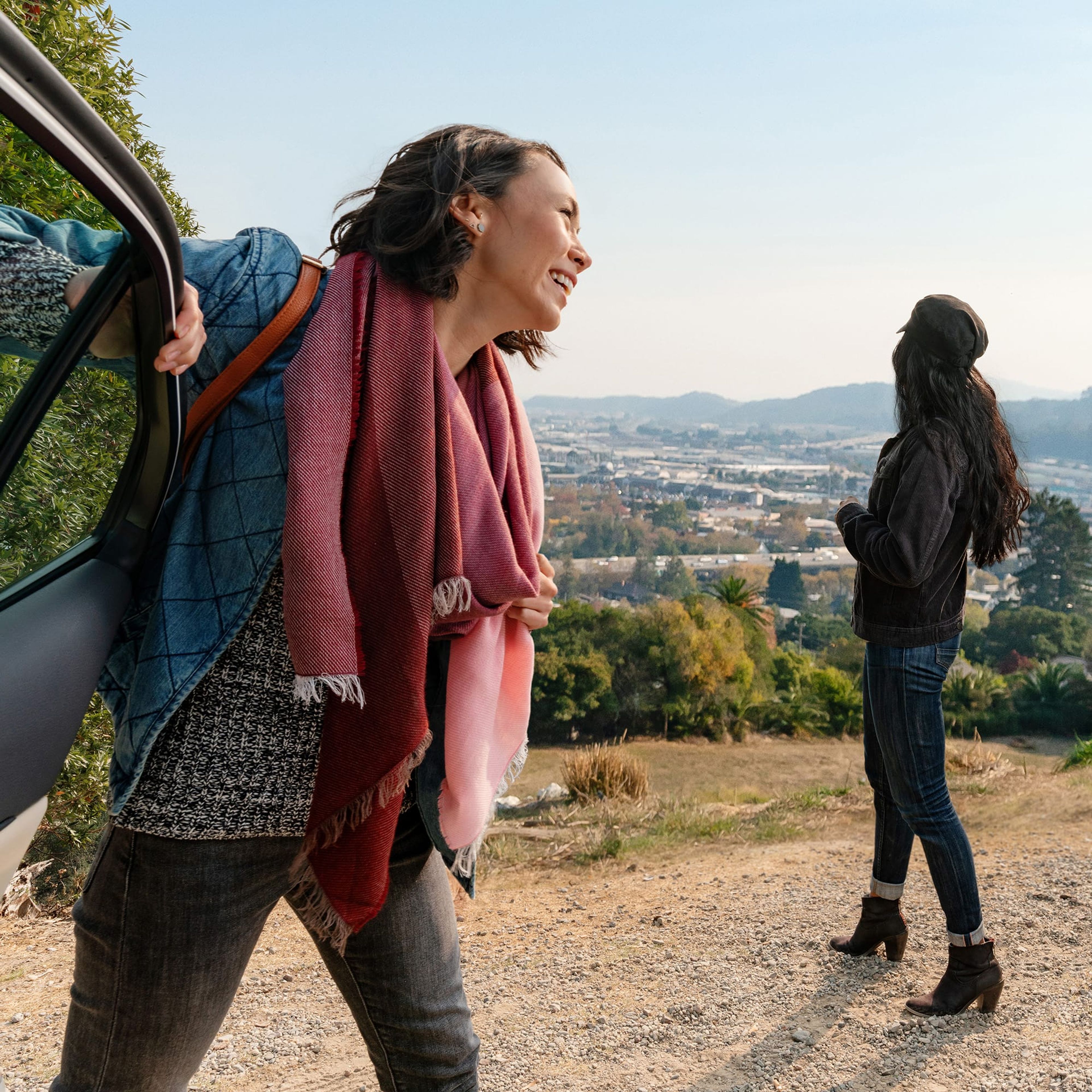 Woman stepping out of a car at a hilltop overlook