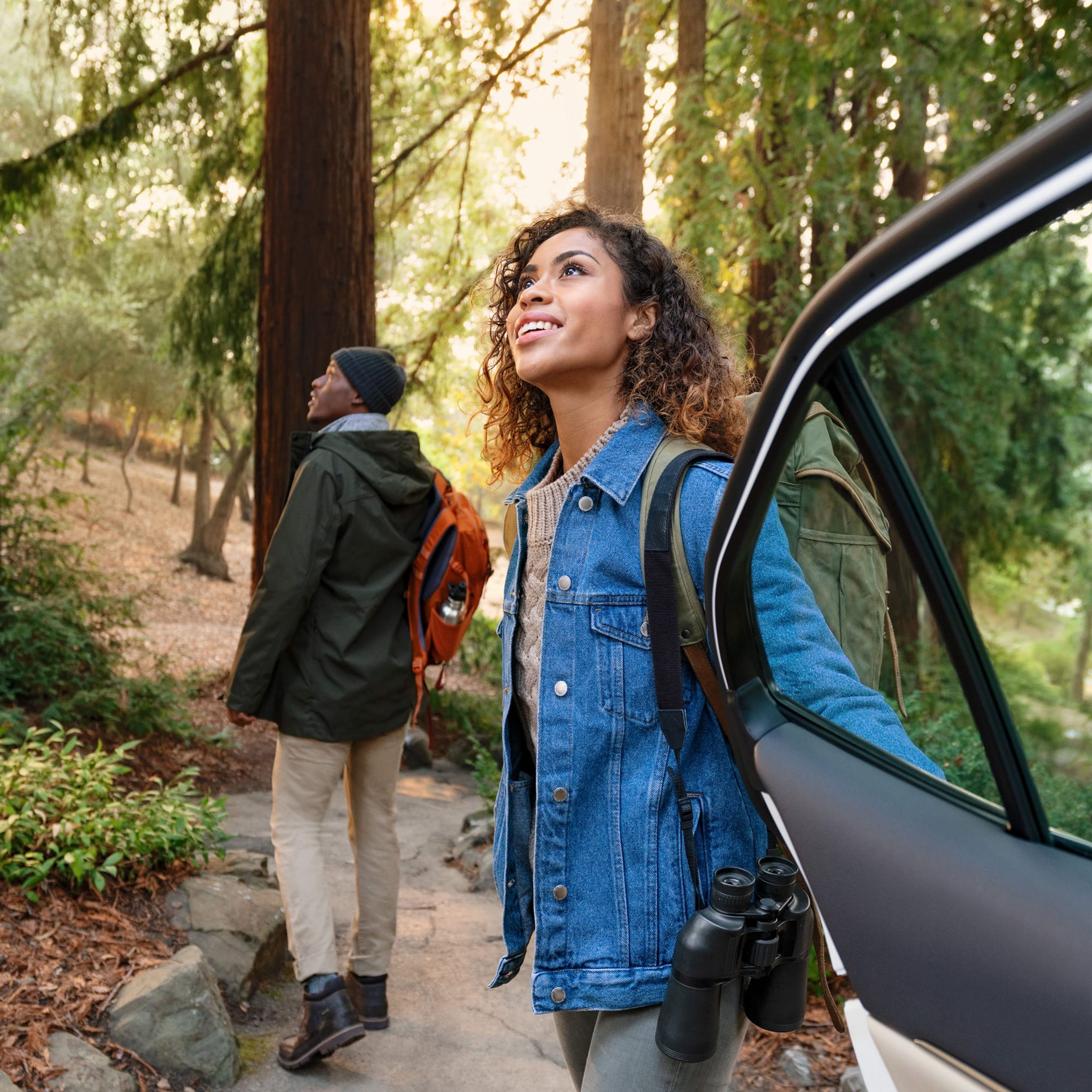 Couple stepping out of a car at a redwood trail