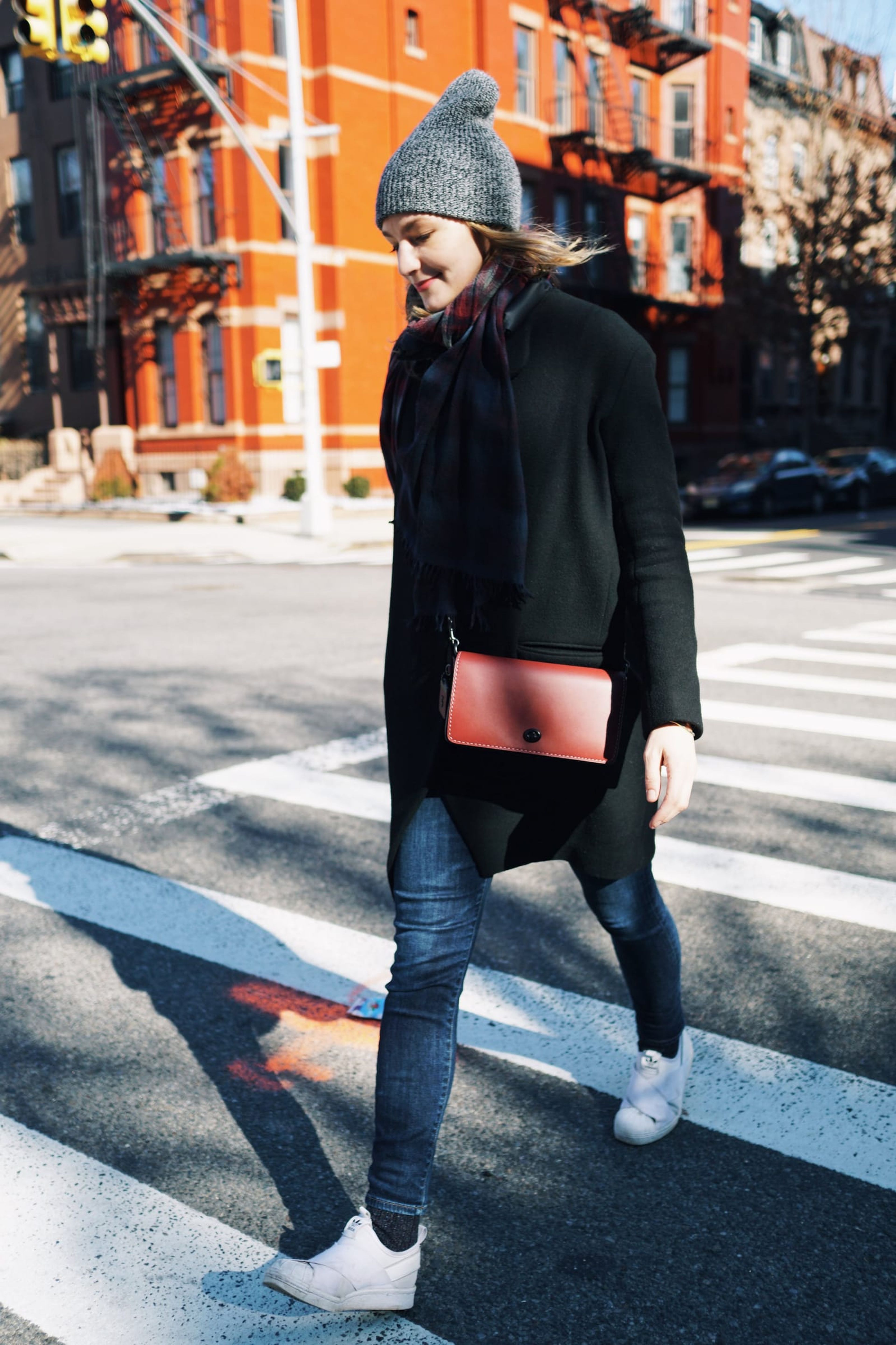 Coach: woman with a pink Coach bag crossing a street