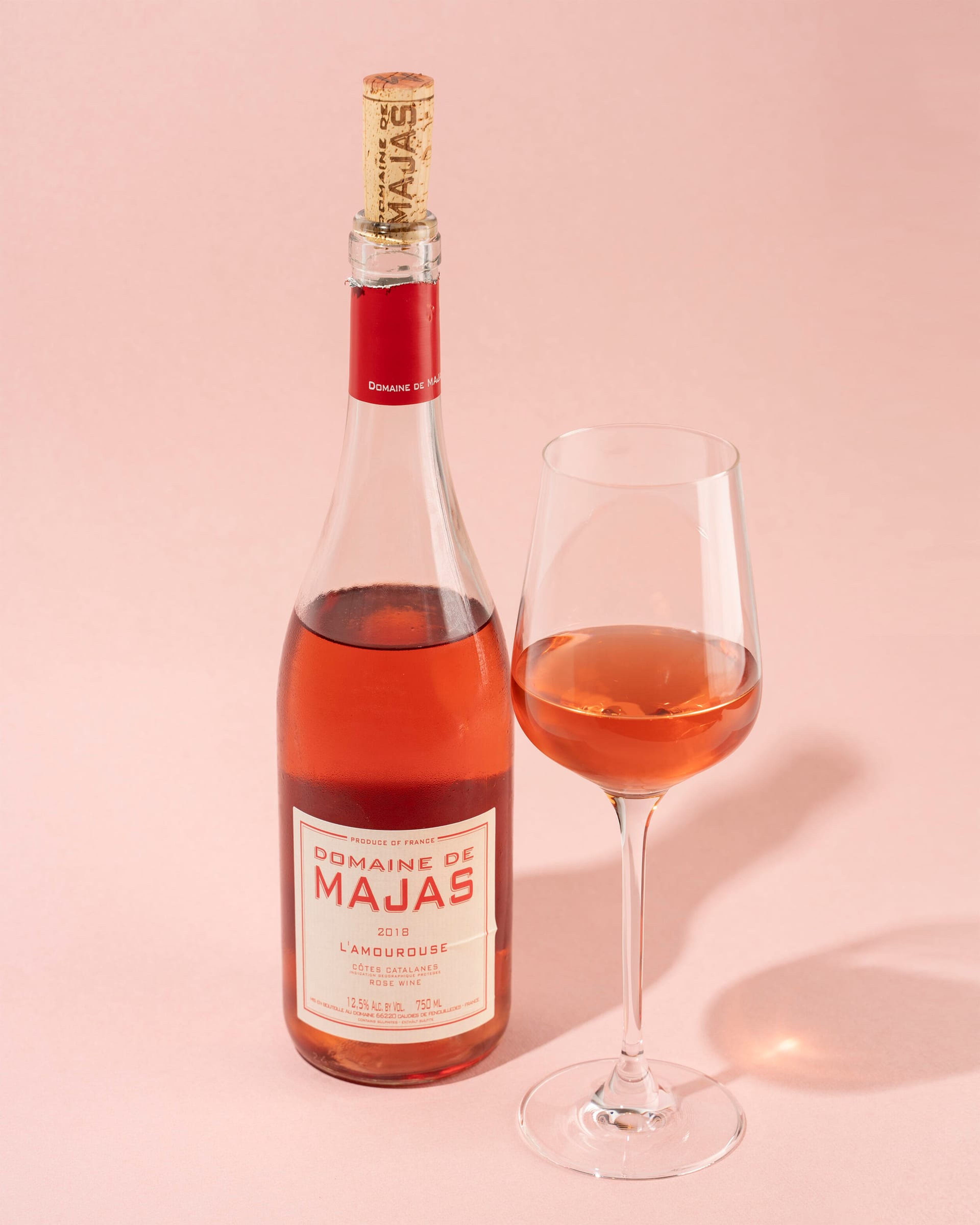 Domaine de Majas rosé bottle and glass on pink