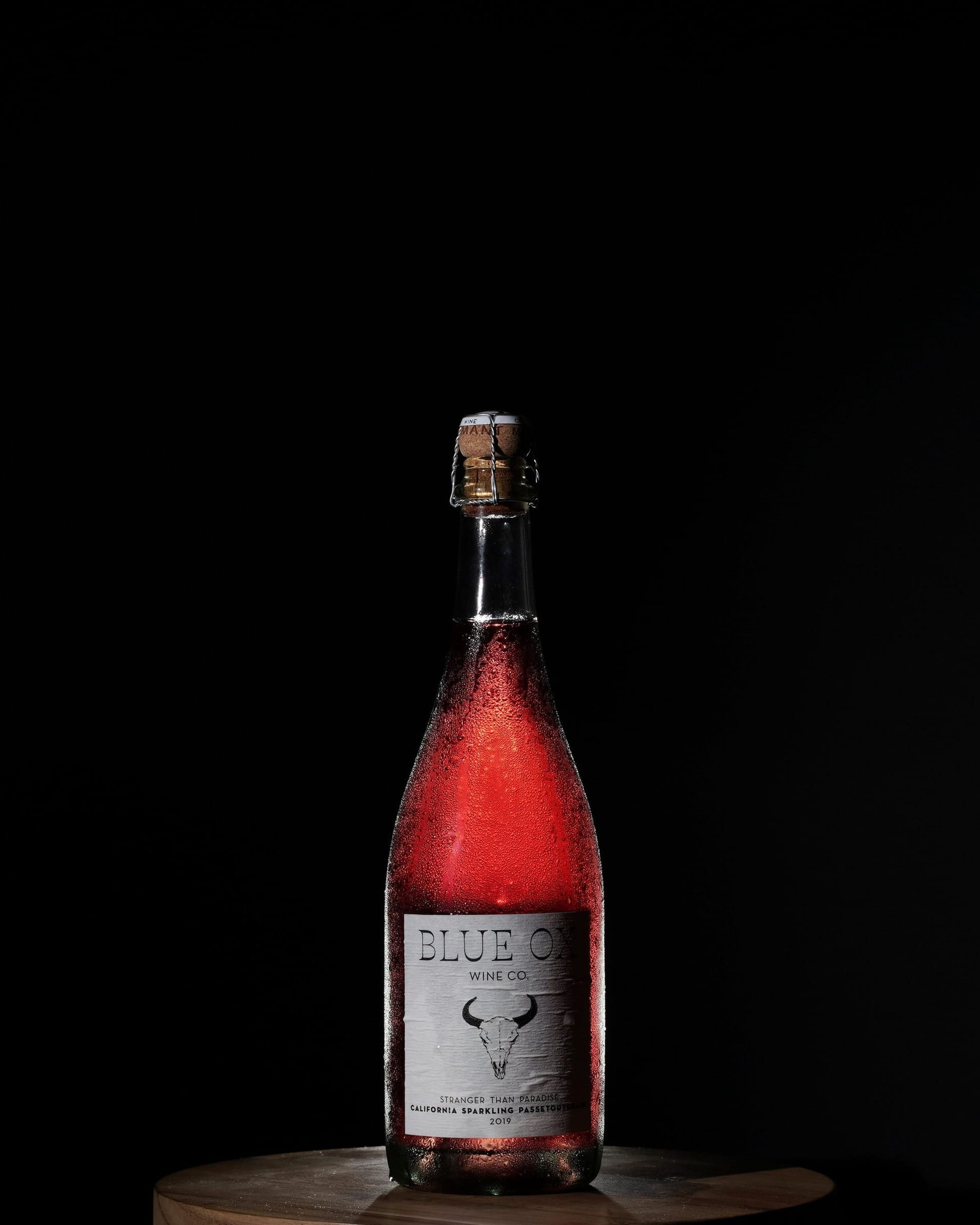 Bottle of Blue Ox sparkling rosé against black