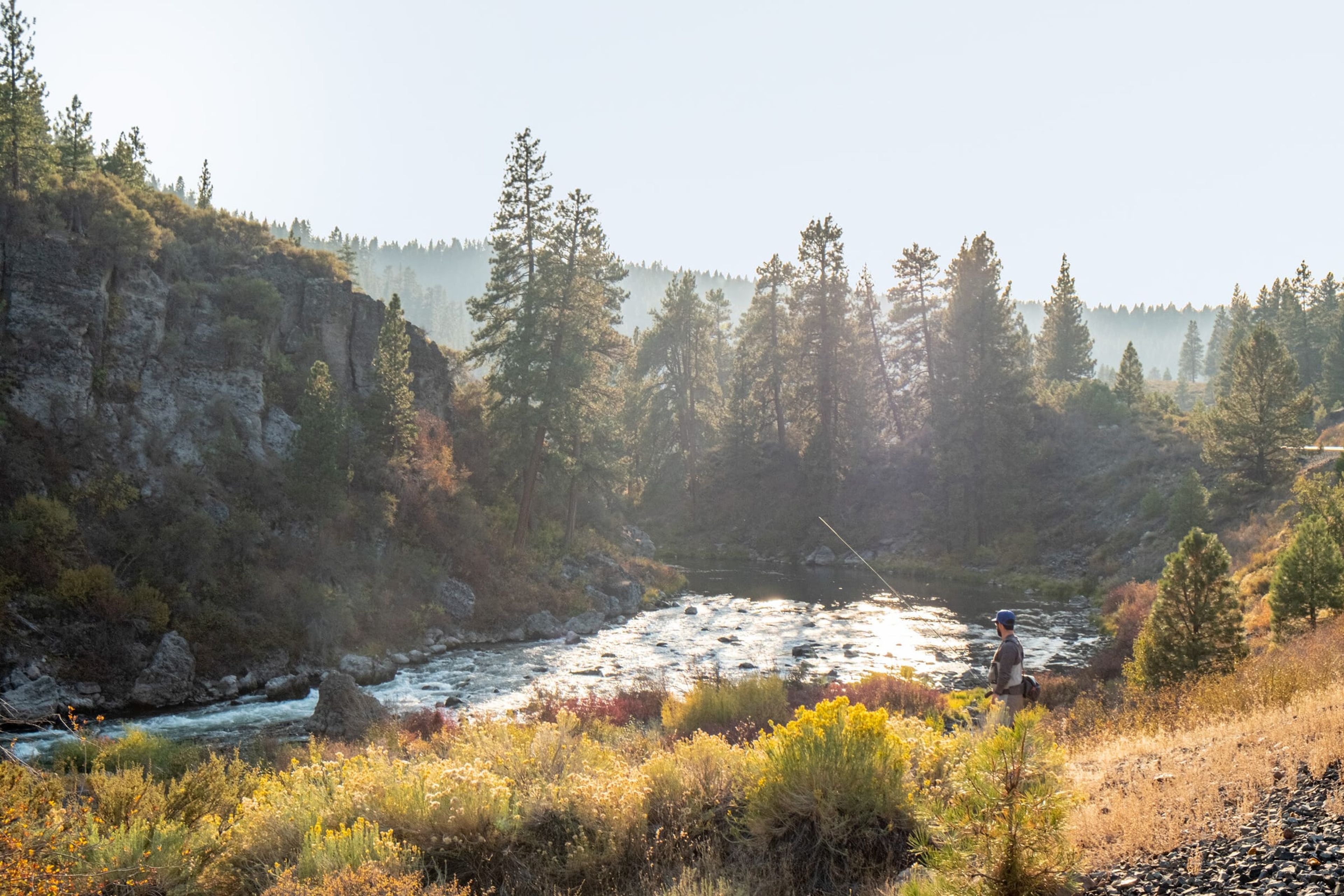 Angler on a canyon river at sunrise