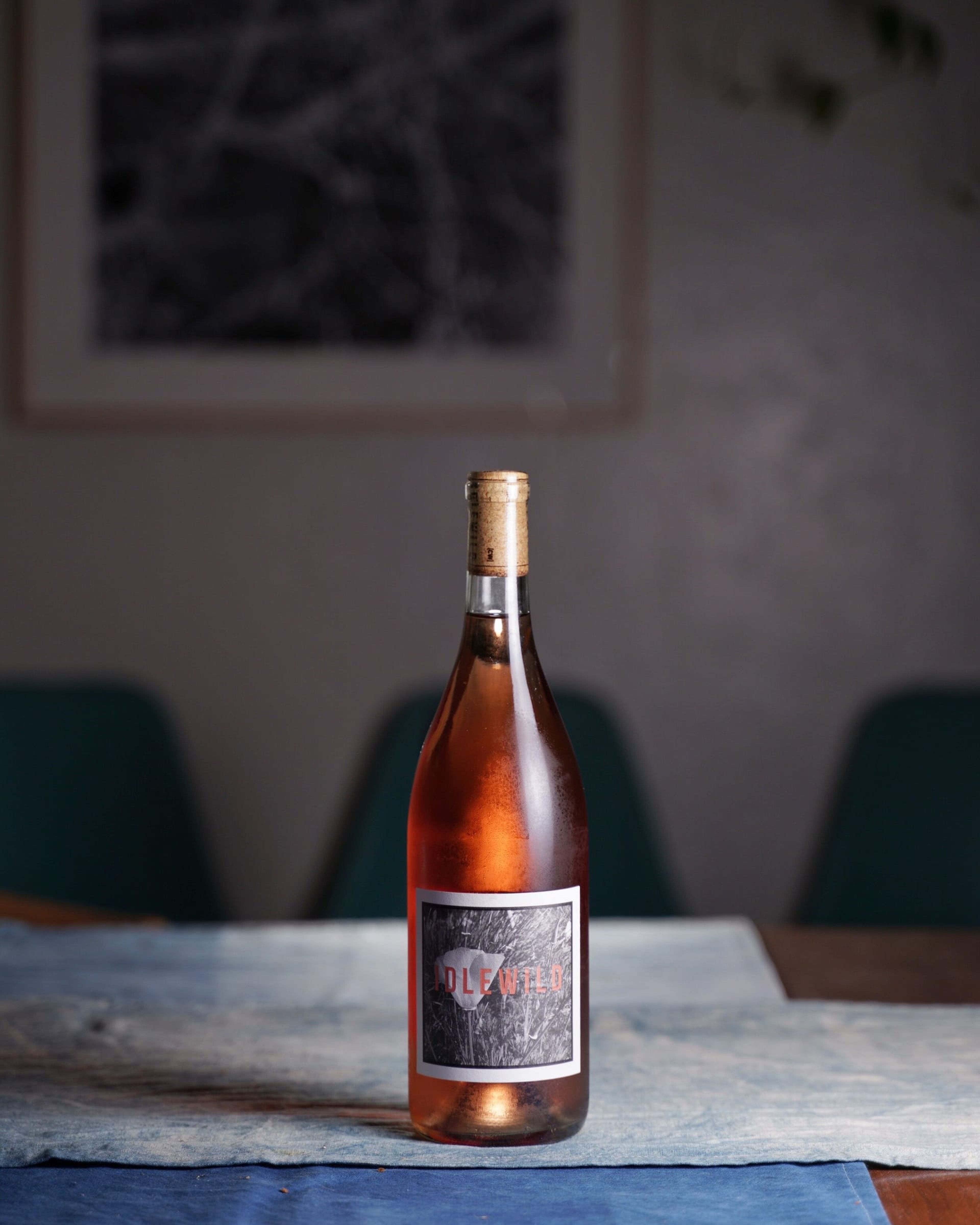 Bottle of rosé on a table in front of blue chairs