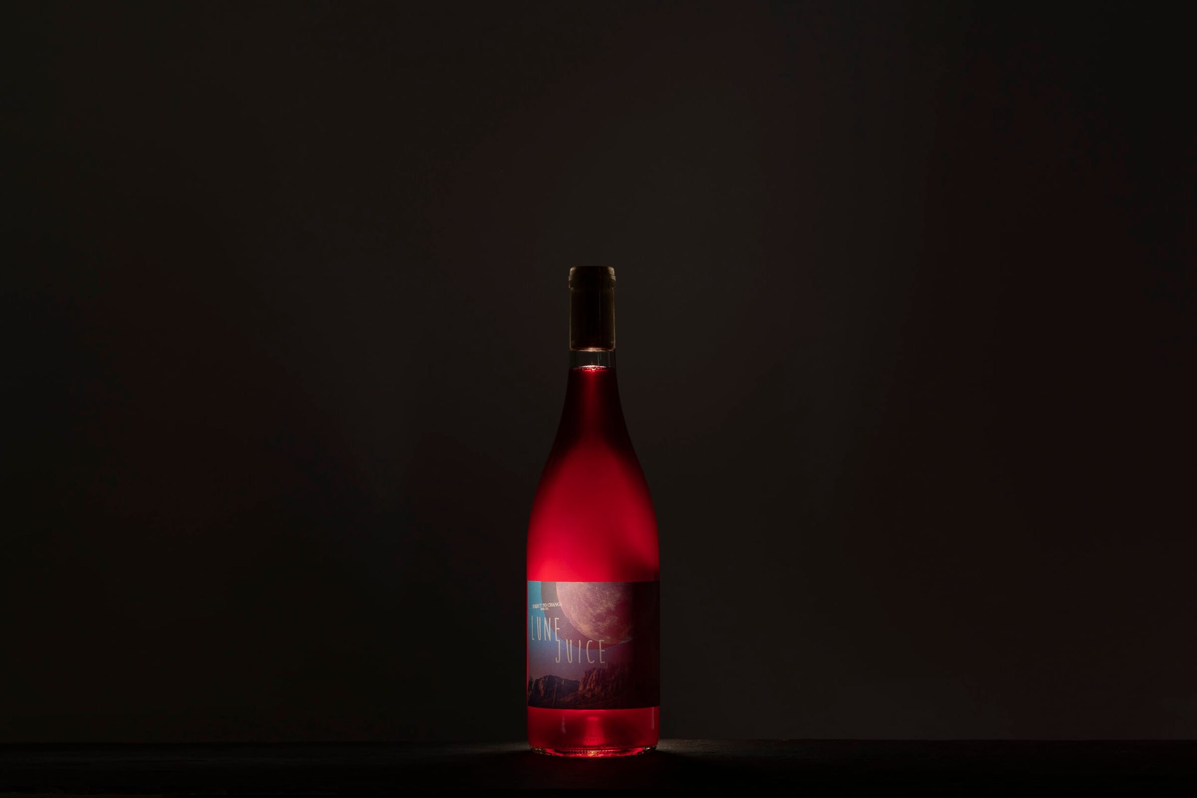 Red-lit bottle of wine in the dark