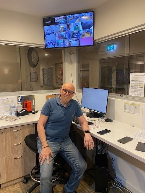 a man is sitting at a desk in front of a computer monitor .